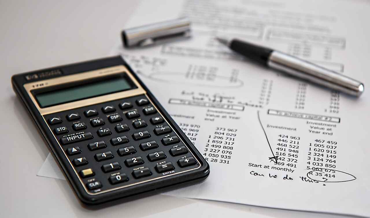 Calculator and pen analyzing figures